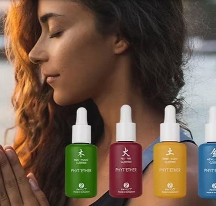 Vrouw met gesloten ogen, met op de voorgrond vier Phyto 5 flesjes in groen, rood, geel en blauw